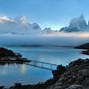 The bridge to Hosteria Pehoe with morning clouds in front of the Horns